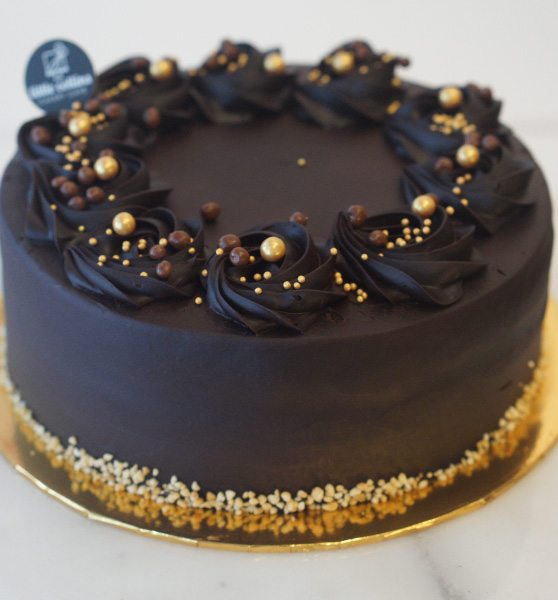 full of chocolate with gold decoration around cake